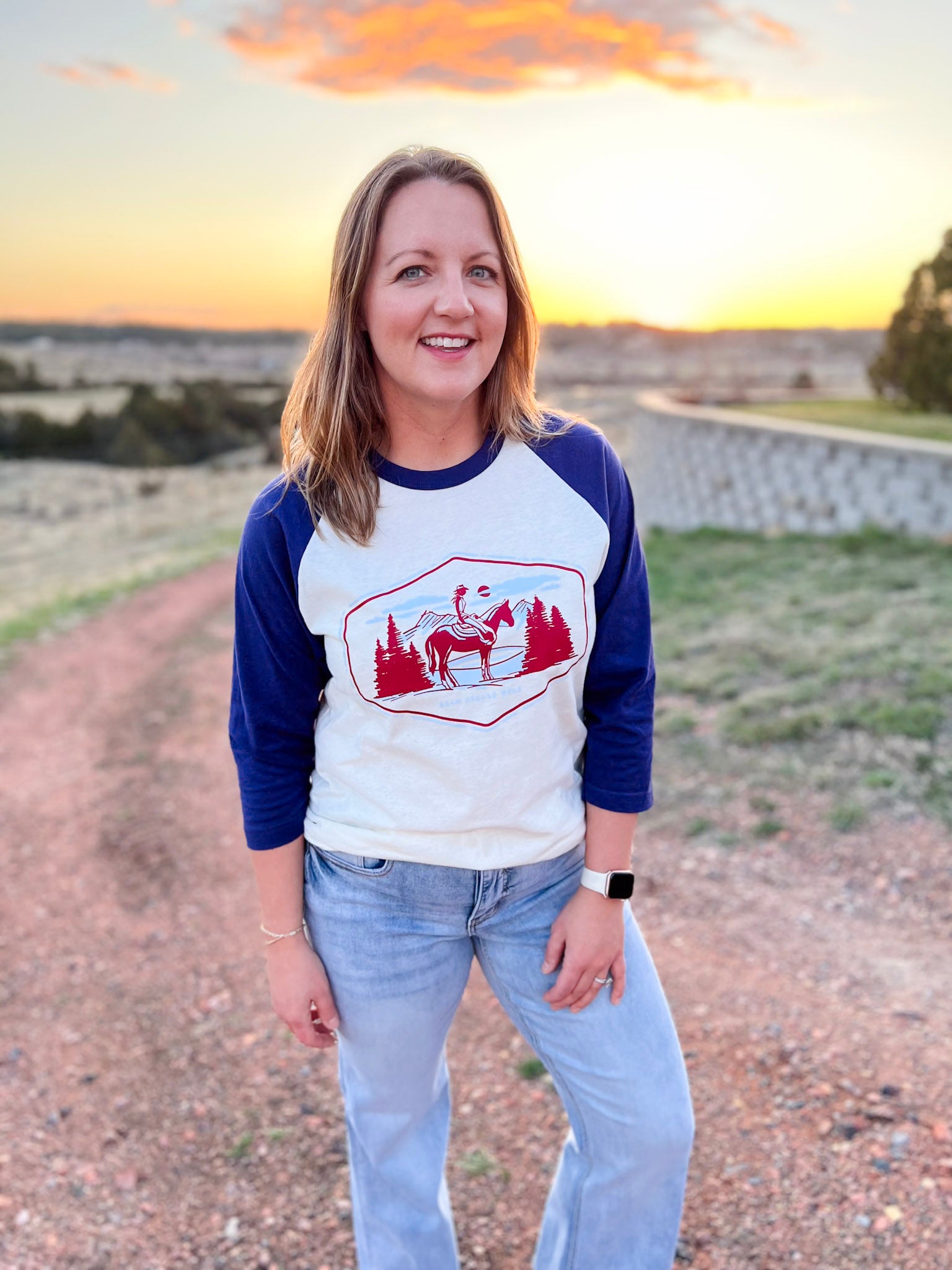 baseball sleeve raglan tee in navy and white with a cowgirl on horse rider imprint in burgundy and powder blue. Summer shirt. Western Americana. Wyoming Americana. Roam Around Wear is a Wyoming t-shirt company based out of Gillette, Wyoming