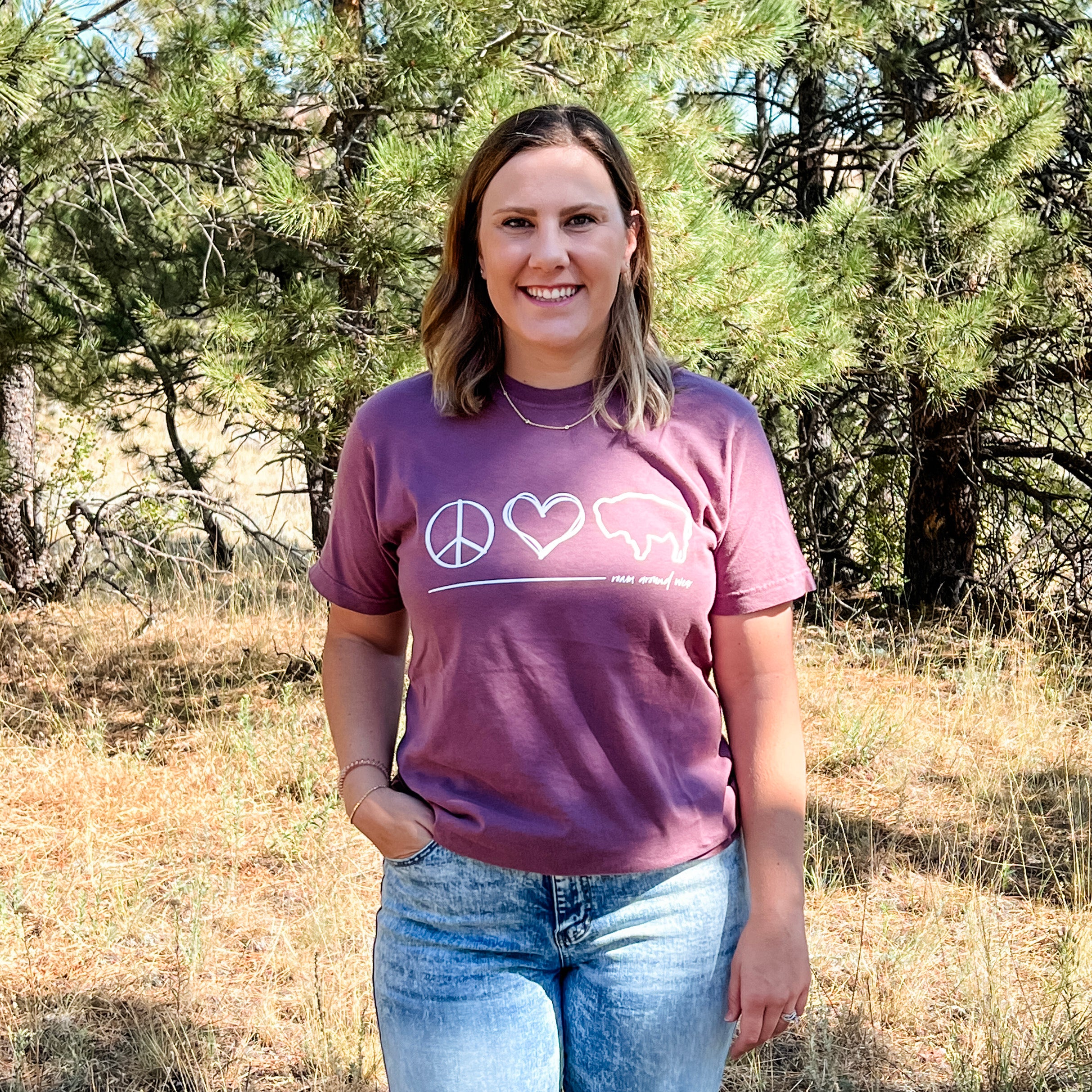 Peace, love, bison design in white on burgundy tee. Roam Around Wear is a women owned Wyoming T-Shirt company based out of Gillette, Wyoming.