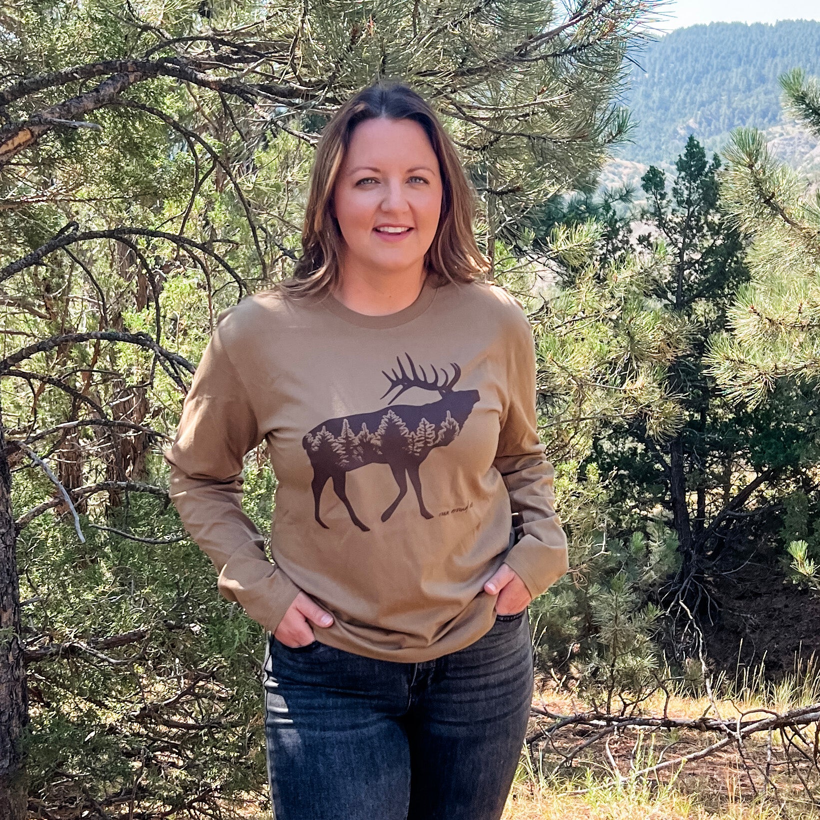 Brown elk forest design on long sleeve brown shirt. Wyoming shirt. Unisex long sleeve shirt. Roam Around Wear is a Wyoming t-shirt company based out of Gillette, Wyoming